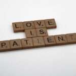 klocki scrabble ułożone w napis "LOVE IS PATIENT"