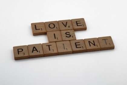 klocki scrabble ułożone w napis "LOVE IS PATIENT"