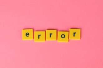 Żółte kwadratowe kafelki z literami układają się w słowo „error” na różowym tle.