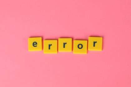 Żółte kwadratowe kafelki z literami układają się w słowo „error” na różowym tle.