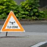 trójkąt ostrzegawczy z napisem "fly zone" stojący na ulicy
