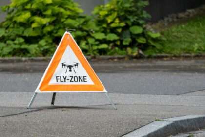 trójkąt ostrzegawczy z napisem "fly zone" stojący na ulicy