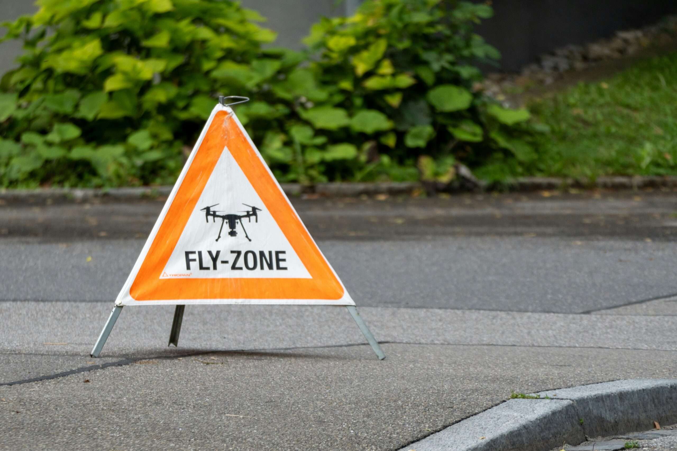 trójkąt ostrzegawczy z napisem "fly zone" stojący na ulicy