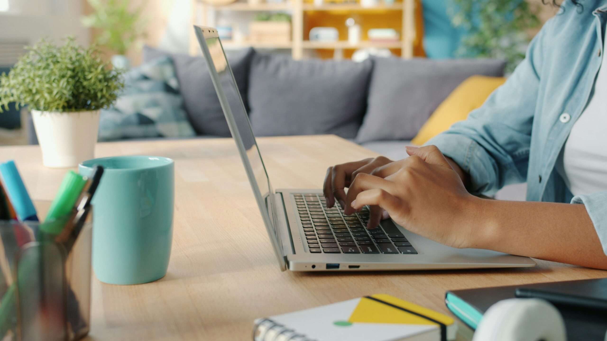 kobieta siedząca przy biurku i pisząca na laptopie
