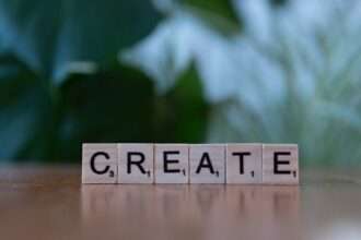 Sześć drewnianych klocków do gry w Scrabble układających się w słowo CREATE.