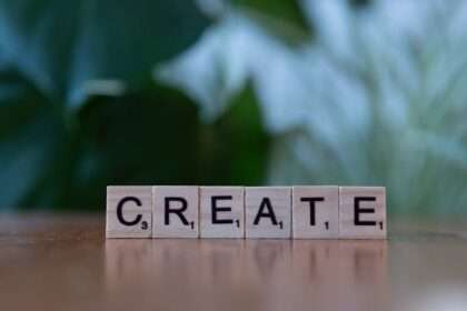 Sześć drewnianych klocków do gry w Scrabble układających się w słowo CREATE.