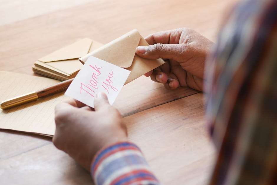 mężczyzna trzymający w ręku karteczkę z napisem "Thank You"