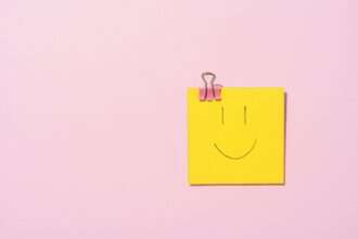 sticky note z uśmiechniętą buźką na różowym tle