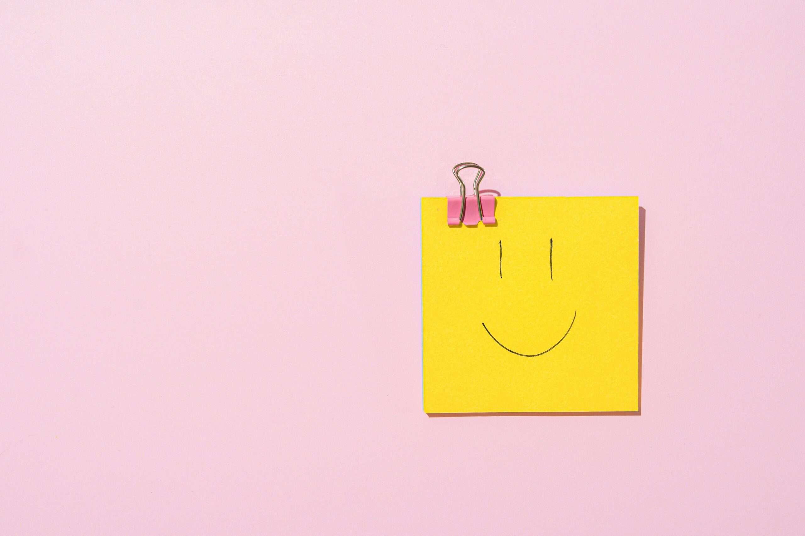 sticky note z uśmiechniętą buźką na różowym tle
